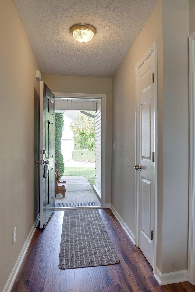 doorway to outside featuring dark hardwood / wood-style floors and a textured ceiling