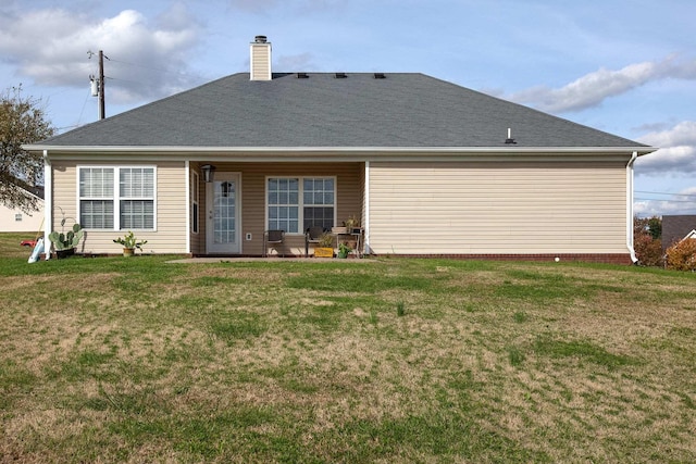 rear view of house featuring a patio and a yard