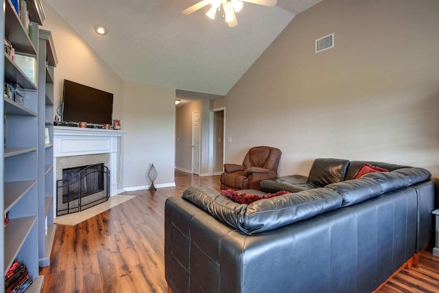 living room with hardwood / wood-style floors, a fireplace, high vaulted ceiling, and ceiling fan