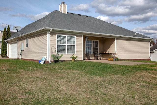 back of house featuring a patio area, a yard, and a garage