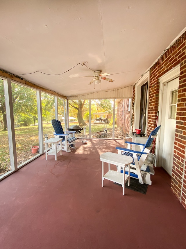 unfurnished sunroom with ceiling fan