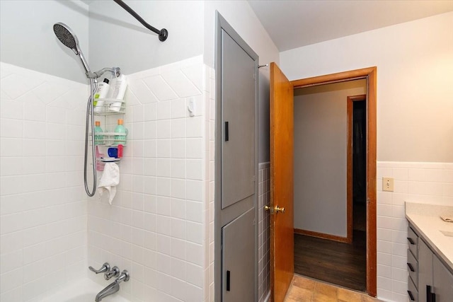 bathroom with vanity, wood-type flooring, tile walls, and bathtub / shower combination