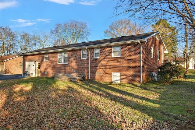 rear view of property with a garage and a yard