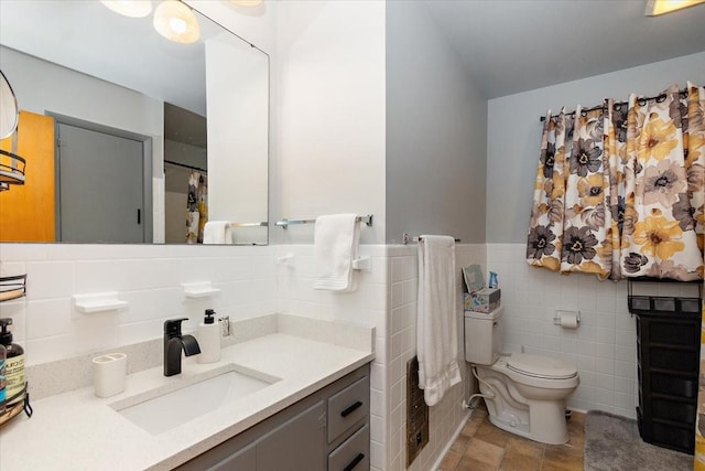 bathroom featuring vanity, toilet, and tile walls