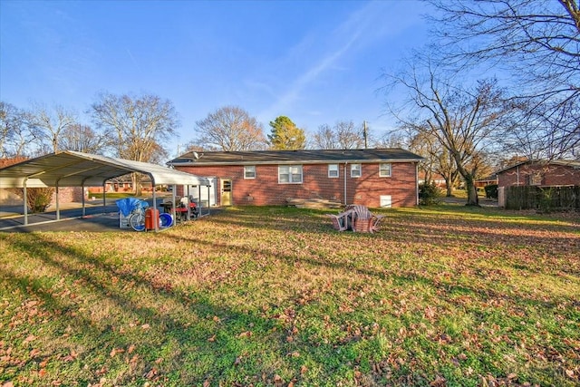 back of property featuring a lawn and a carport