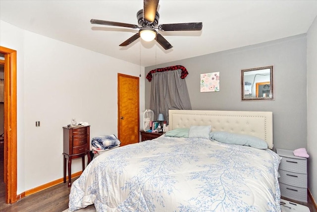 bedroom with dark hardwood / wood-style flooring and ceiling fan