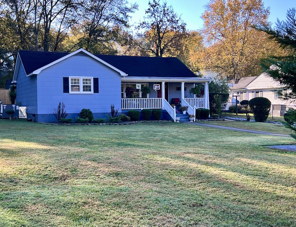 ranch-style house with a porch and a front lawn