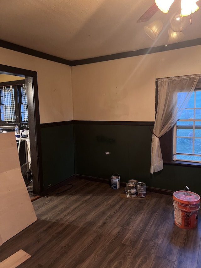 unfurnished room with dark wood-type flooring, ceiling fan, and crown molding