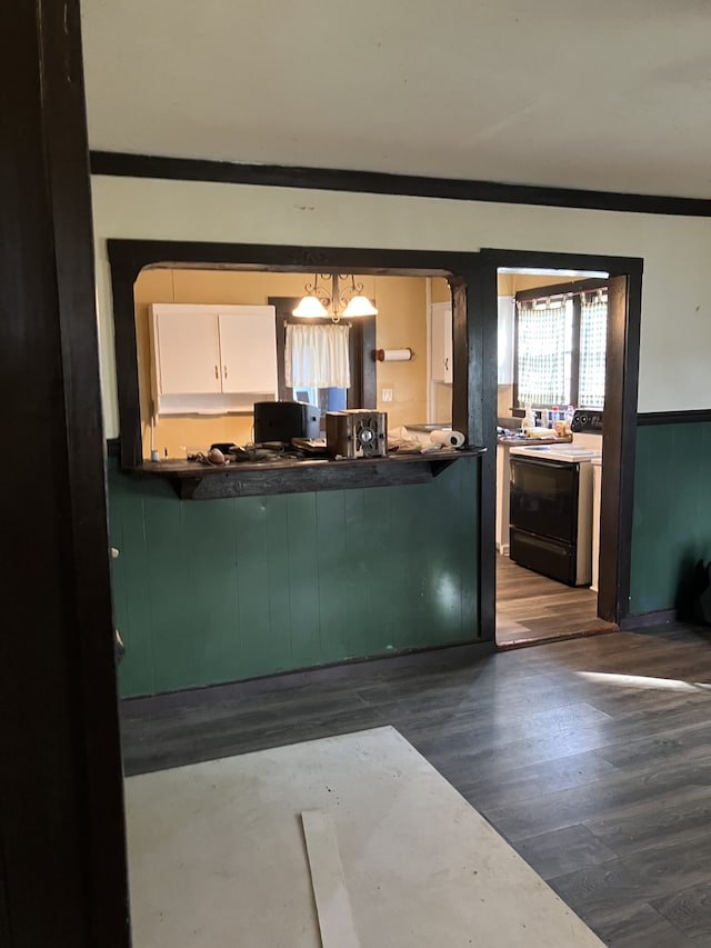 interior space with green cabinetry, electric range, decorative light fixtures, white cabinets, and dark wood-type flooring