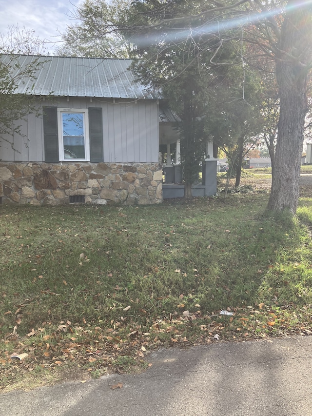 view of side of home with a lawn