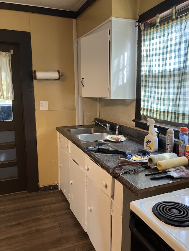 kitchen with dark wood-type flooring, white range oven, sink, white cabinets, and tasteful backsplash