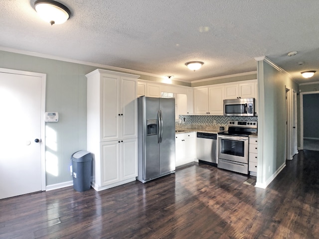 kitchen with appliances with stainless steel finishes, a textured ceiling, white cabinetry, dark wood-type flooring, and crown molding