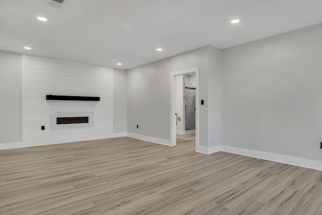 unfurnished living room with a fireplace and light hardwood / wood-style floors