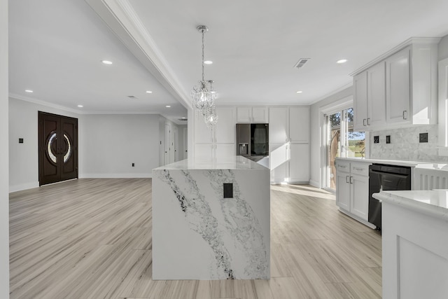 kitchen with black appliances, a kitchen island, white cabinets, crown molding, and light hardwood / wood-style flooring