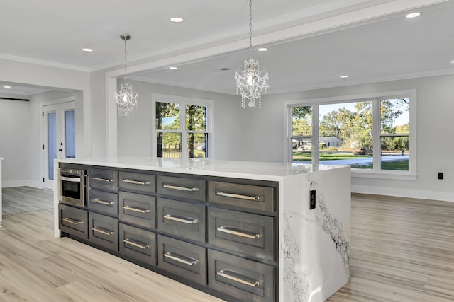 kitchen with a kitchen island, stainless steel oven, hanging light fixtures, light stone counters, and light hardwood / wood-style floors