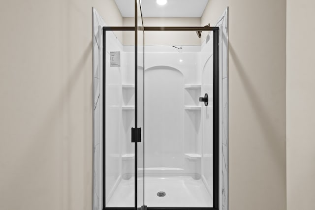 bathroom featuring a shower with door