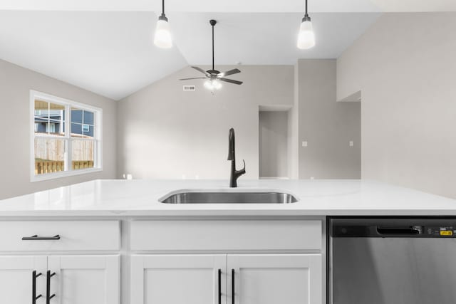 kitchen with pendant lighting, dishwasher, sink, white cabinets, and light stone countertops