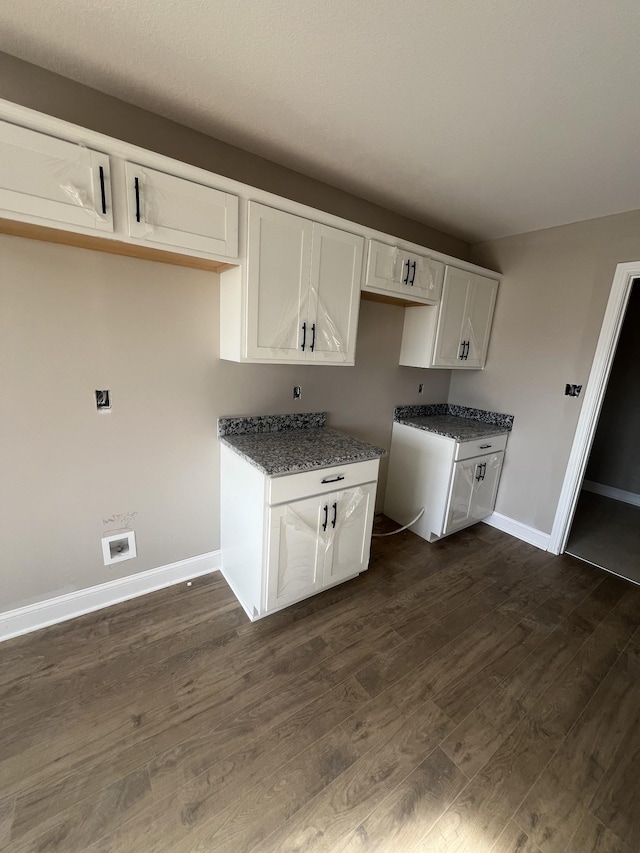 kitchen featuring dark hardwood / wood-style floors, white cabinets, and dark stone counters