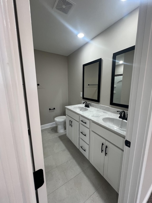 full bathroom with visible vents, a sink, toilet, and double vanity