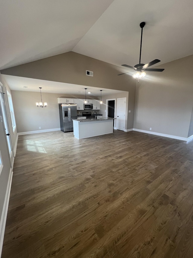 unfurnished living room featuring dark wood-style flooring, visible vents, baseboards, and ceiling fan with notable chandelier