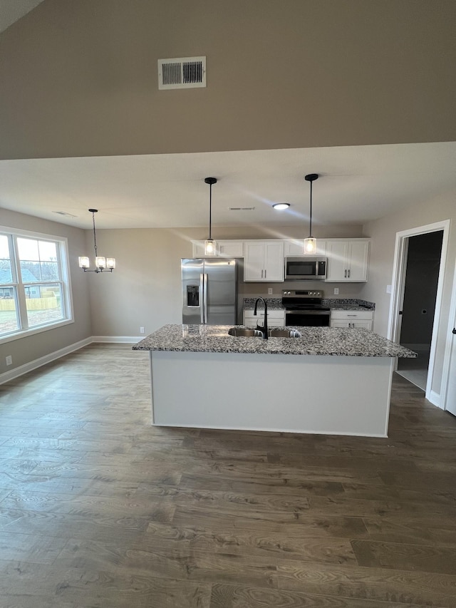 kitchen with stainless steel appliances, light stone countertops, visible vents, and white cabinets