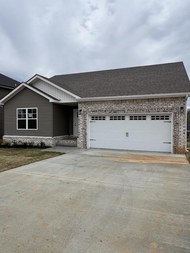 ranch-style home with an attached garage, roof with shingles, concrete driveway, and brick siding