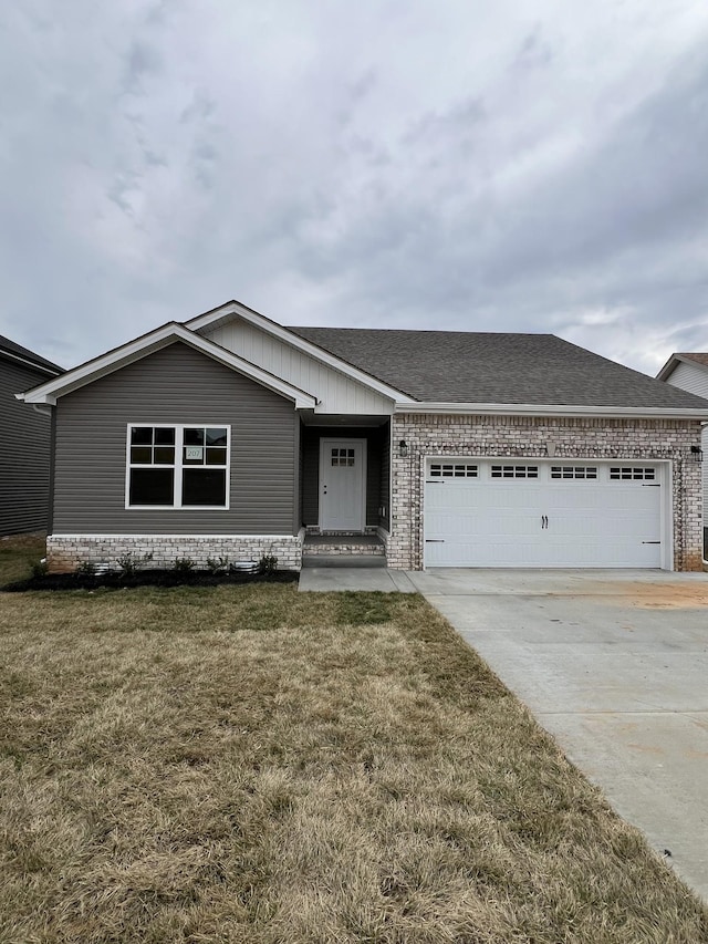 ranch-style house with a garage, driveway, a shingled roof, brick siding, and a front yard