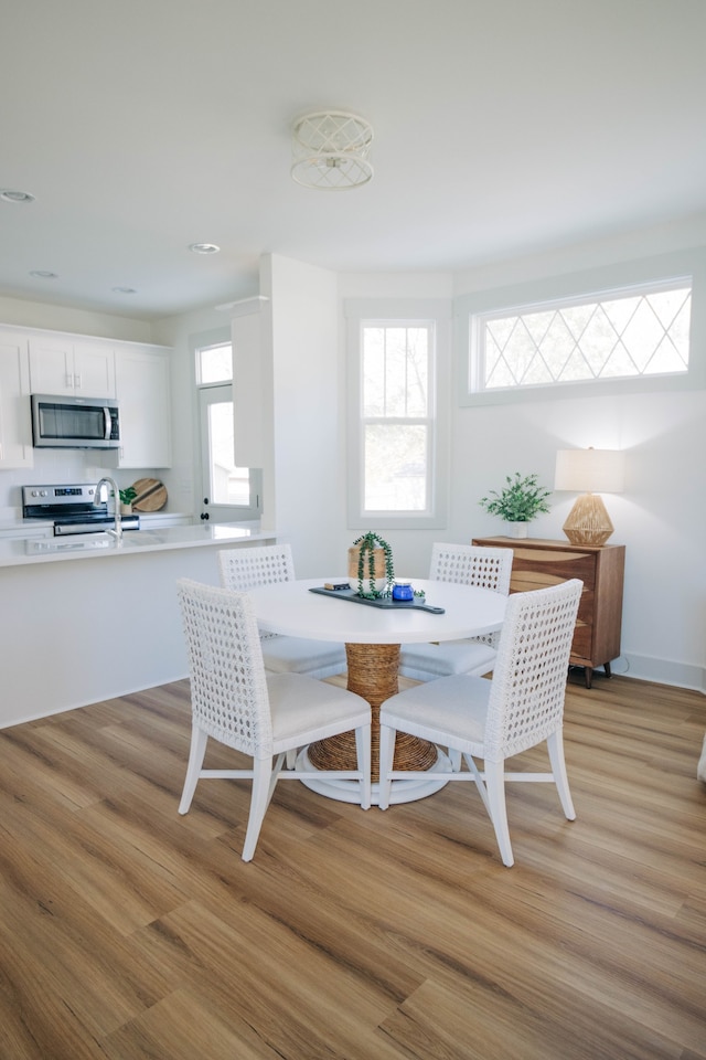 dining space with sink and light wood-type flooring