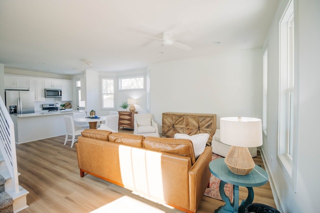 living room featuring light hardwood / wood-style flooring and ceiling fan