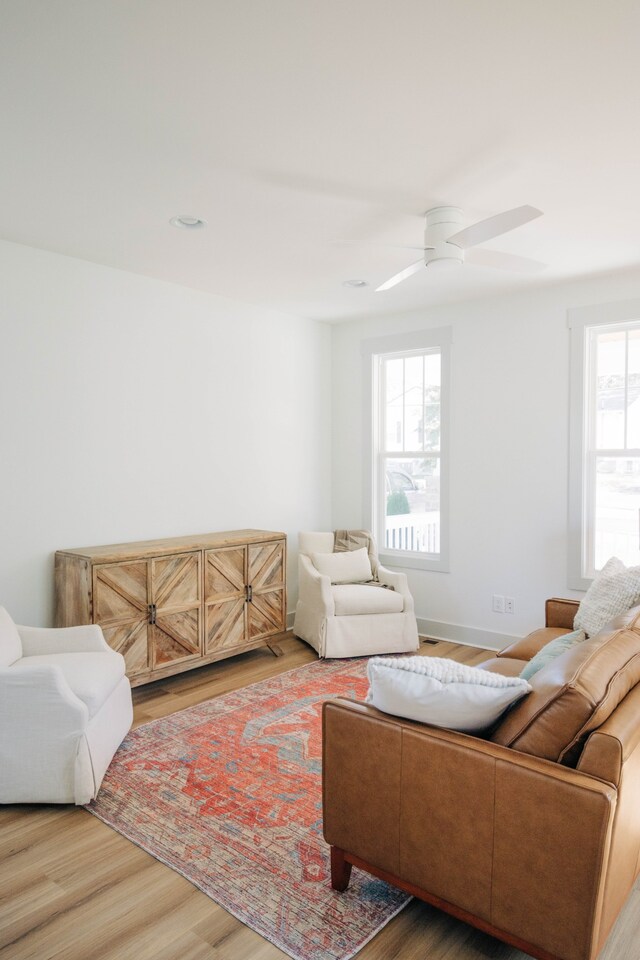 living room with a wealth of natural light, hardwood / wood-style flooring, and ceiling fan