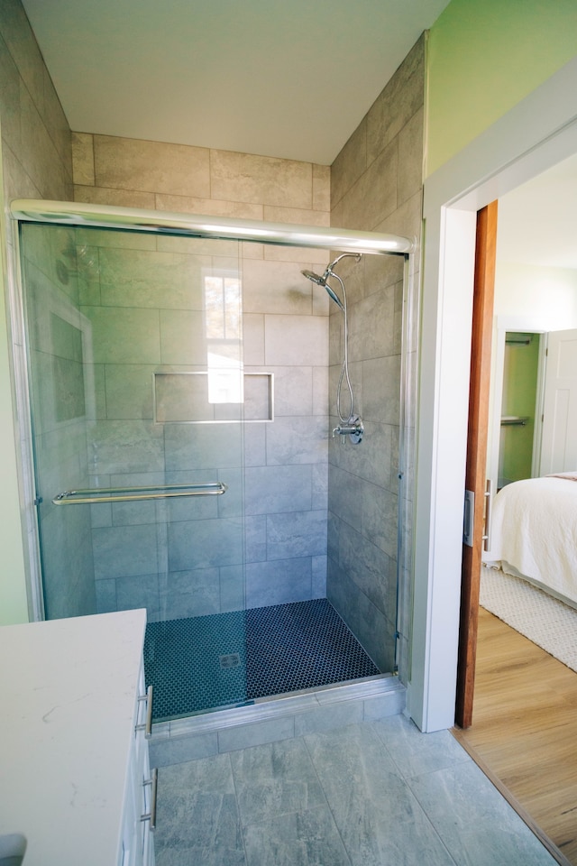 bathroom with vanity, an enclosed shower, and wood-type flooring