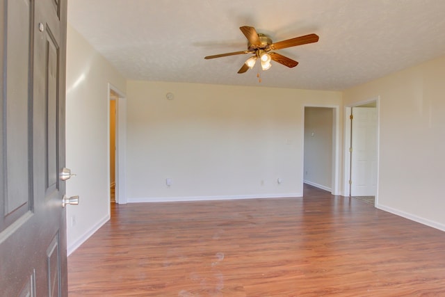 unfurnished room featuring a textured ceiling, wood-type flooring, and ceiling fan