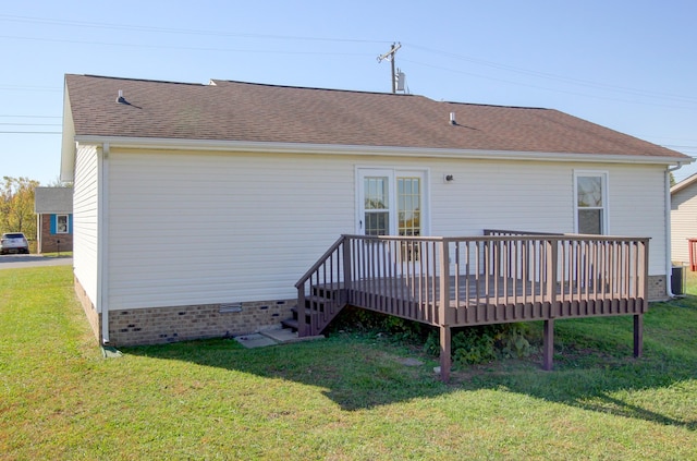 rear view of house with a wooden deck and a lawn