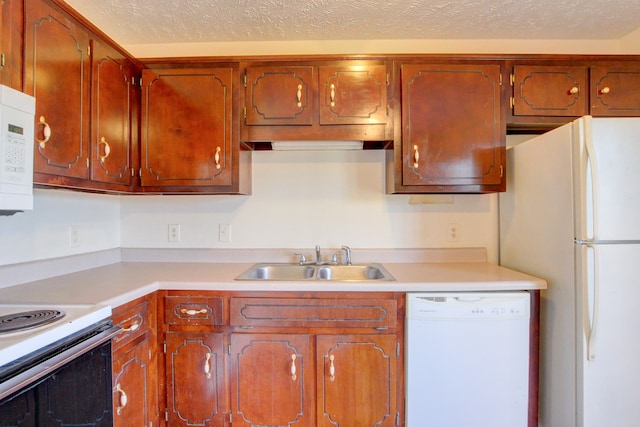 kitchen with white appliances, a textured ceiling, and sink