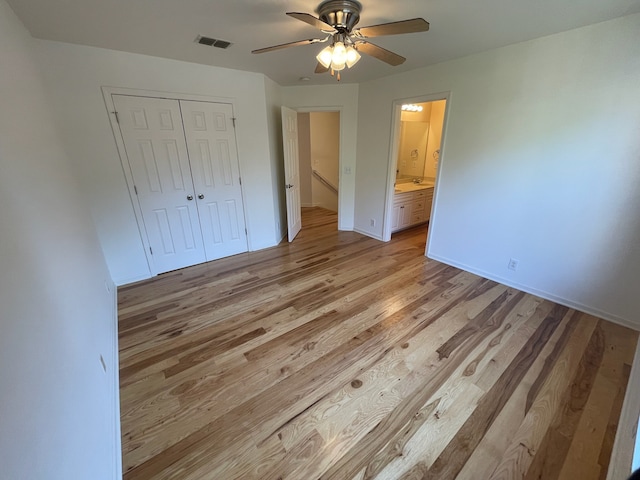 unfurnished bedroom with a closet, ceiling fan, ensuite bathroom, and light hardwood / wood-style floors