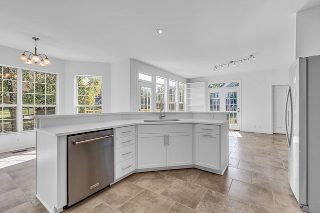 kitchen with white cabinets, stainless steel appliances, pendant lighting, a notable chandelier, and a center island