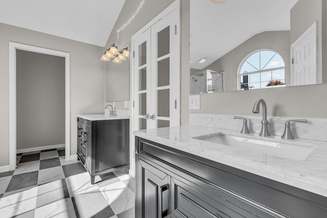 bathroom with a shower with door, vanity, and vaulted ceiling