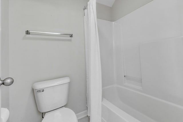 bathroom with shower / bath combo with shower curtain and toilet