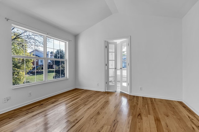 empty room featuring lofted ceiling and light wood-type flooring