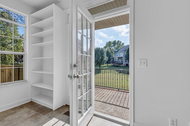 doorway to outside with light tile patterned flooring