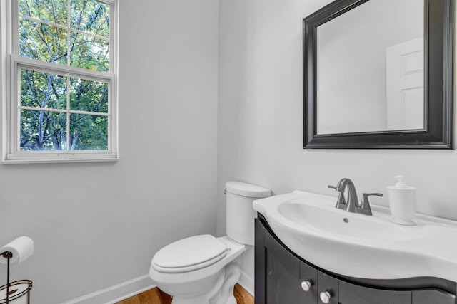 bathroom with vanity, toilet, and wood-type flooring