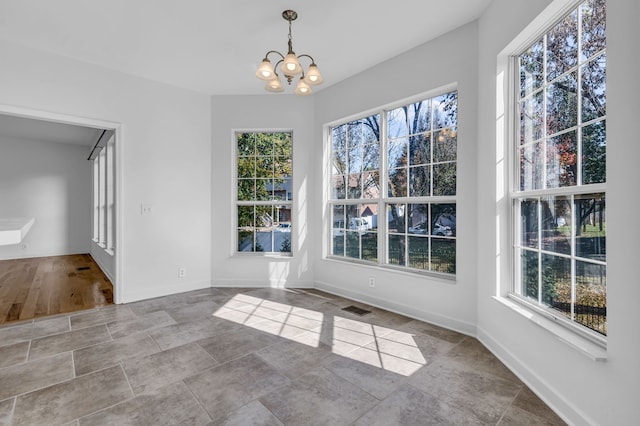 unfurnished dining area featuring a wealth of natural light, a chandelier, and light hardwood / wood-style flooring