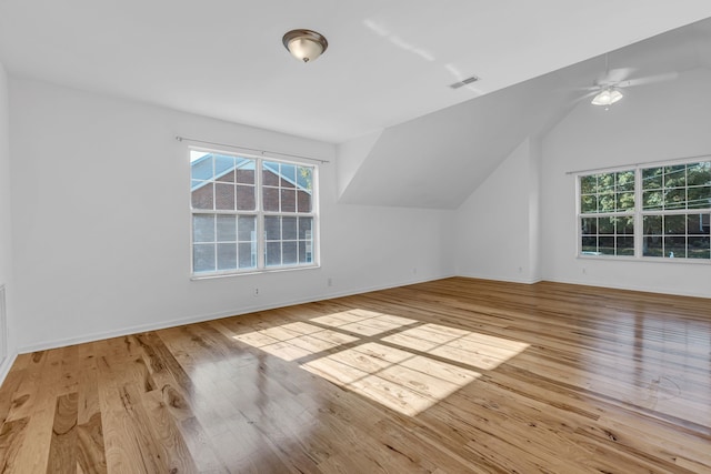 additional living space with ceiling fan, lofted ceiling, and light wood-type flooring