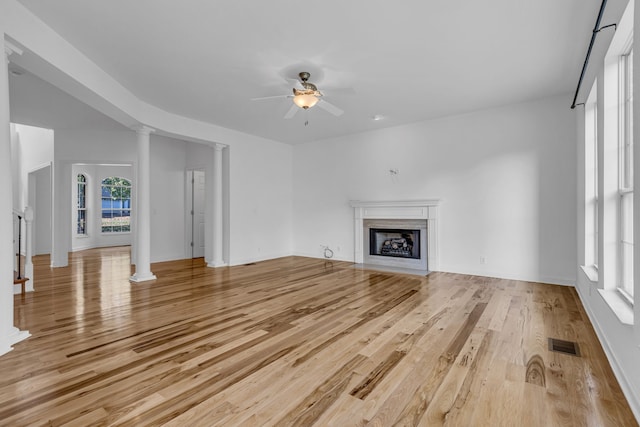 unfurnished living room featuring ornate columns, light hardwood / wood-style floors, and ceiling fan