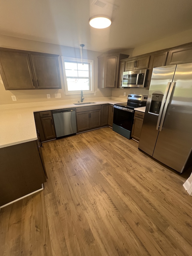 kitchen featuring sink, appliances with stainless steel finishes, and light hardwood / wood-style flooring