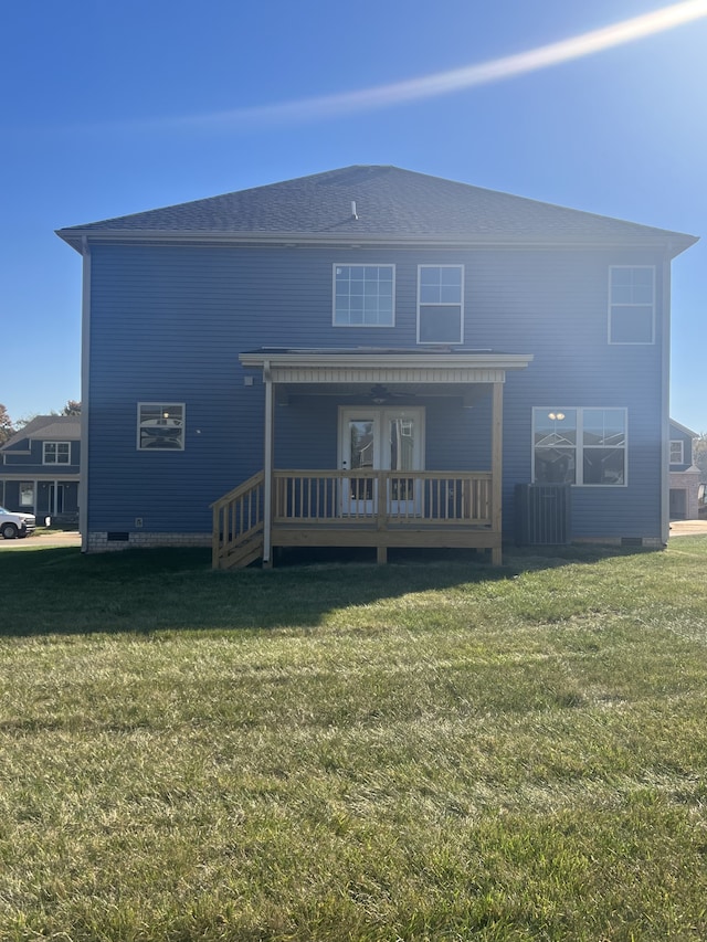 rear view of property featuring a lawn