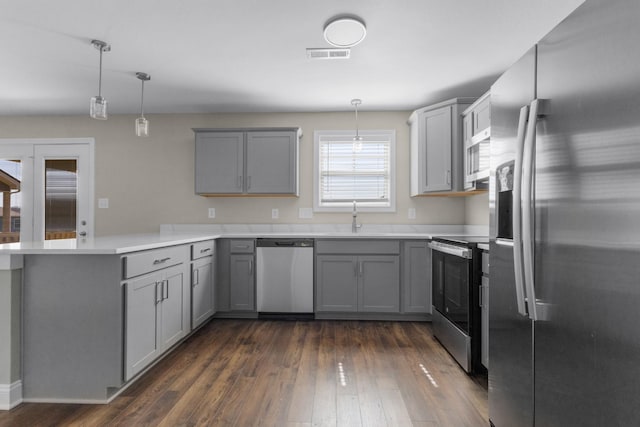 kitchen with a peninsula, appliances with stainless steel finishes, gray cabinets, and visible vents