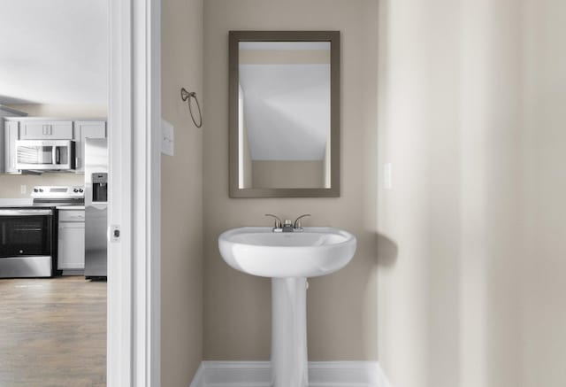 bathroom with baseboards and wood finished floors