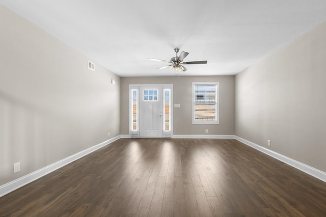 interior space featuring dark wood-style floors, baseboards, visible vents, and a ceiling fan