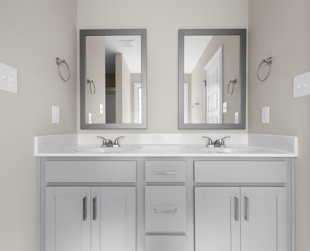 full bath with visible vents, a sink, and double vanity